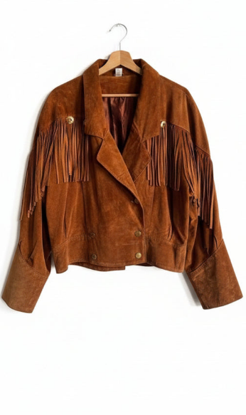 black suede jacket with fringes on a hanger against a white background