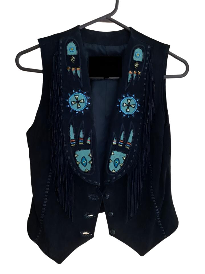 A black suede leather fringe vest with Paw beaded detailing and a button front closure, displayed on a hanger.