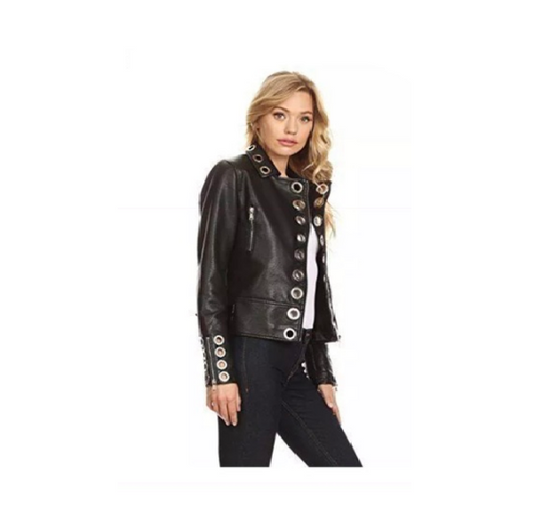 A woman wearing a black leather biker jacket with silver metal ring detailing, paired with blue jeans.